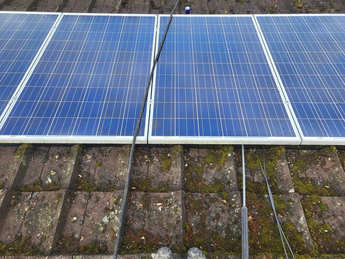 Solar panels with mossy roof tiles before cleaning